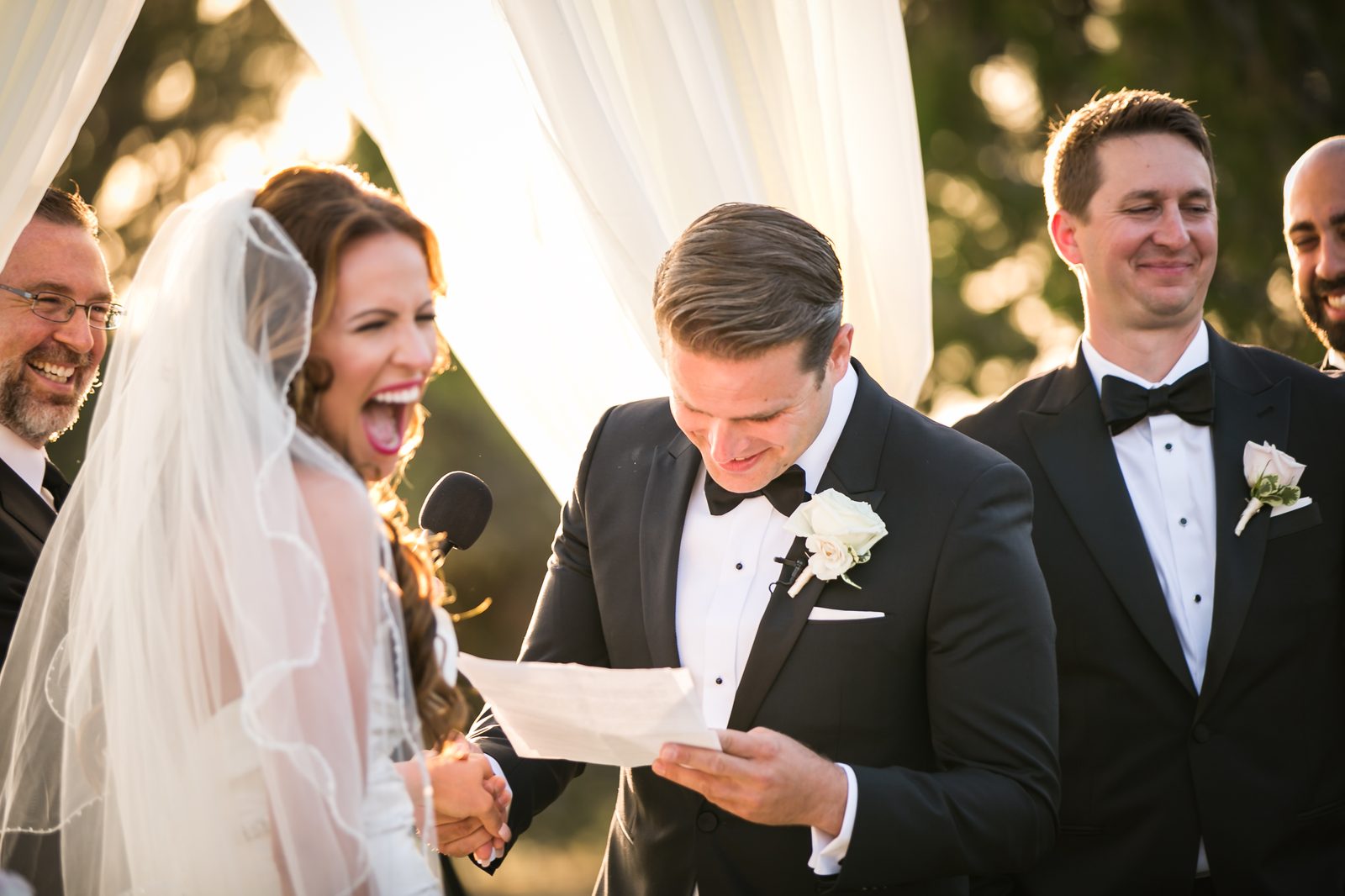 Couple laughing during vows at golden hour